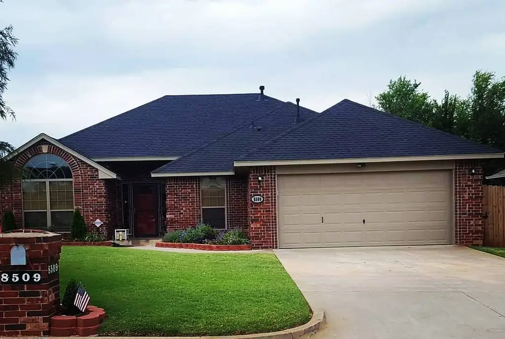 Completed dark charcoal shingle roof on a brick single-story Oklahoma City home