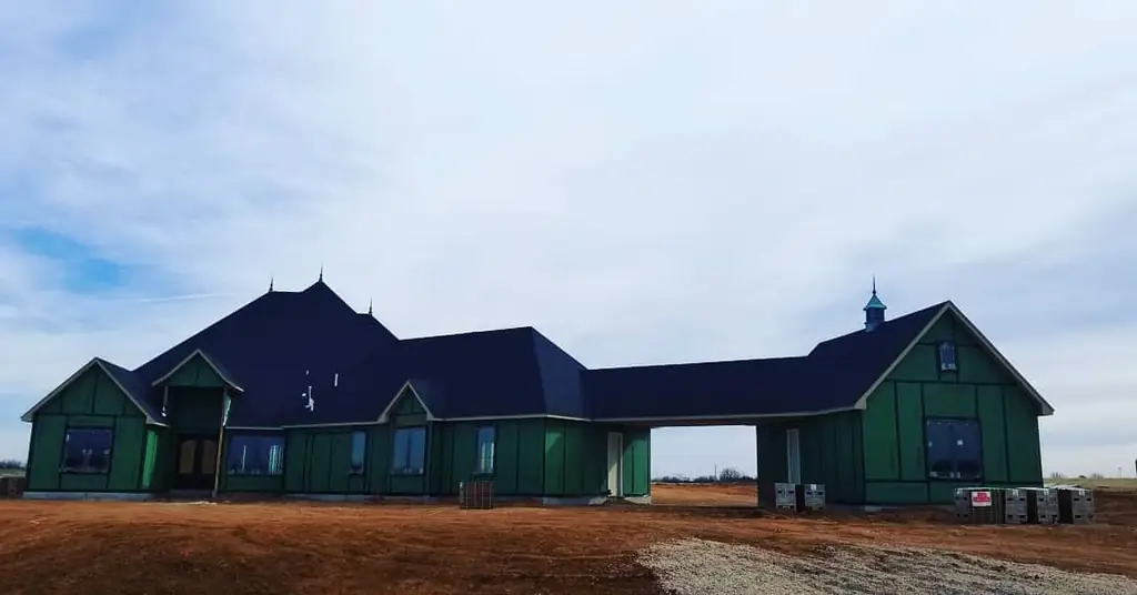 Large custom Oklahoma City home with a dark shingle roof and multiple gables and dormers